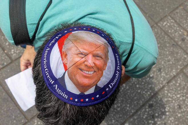 22일 뉴욕에서 열린 이란 공격 반대 집회에서 한 시위자가 도널드 트럼프 대통령 모습이 새겨진 유대교 모자를 보여주고 있다. /연합뉴스