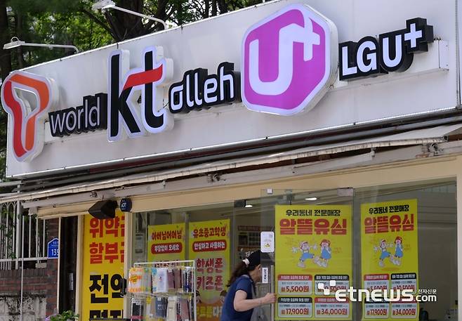 SK텔레콤 유심칩 해킹 사태가 촉발한 통신사 보조금 경쟁이 치열해지고 있다. 주말 서울 시내 한 이동통신사 대리점 앞을 지나는 시민들. 김민수기자 mskim@etnews.com