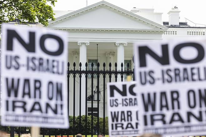 시위대가 22일 미국 워싱턴 디시(D.C.) 백악관 앞에서 도널드 트럼프 미국 대통령의 이란 내 핵시설 폭격 결정에 반대하는 목소리를 내고 있다. 워싱턴/EPA 연합뉴스