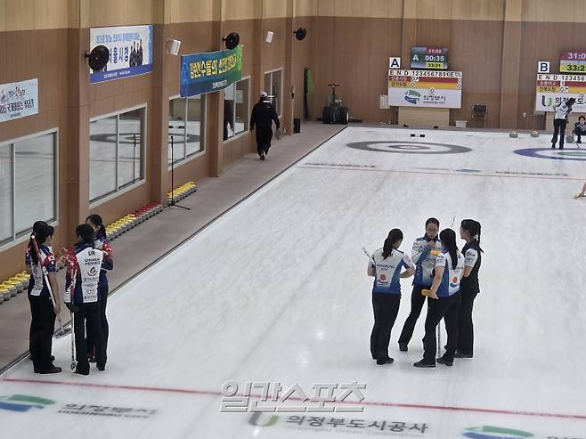 23일 의정부 컬링경기장에서 열린 2025 한국컬링선수권대회 라운드로빈 6차전 중 작전을 회의하고 있는 경기도청(왼쪽)과 강릉시청(오른쪽). 의정부=김우중 기자
