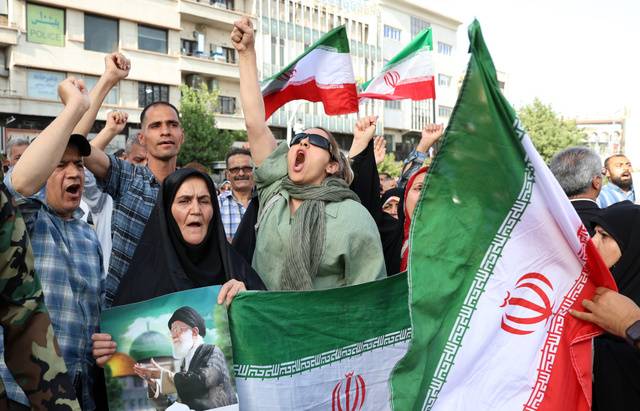 이란 수도 테헤란에서 22일(현지시간) 시민들이 국기와 최고지도자 아야톨라 알리 하메네이 사진을 들고 반미·반이스라엘 구호를 외치고 있다. EPA연합뉴스