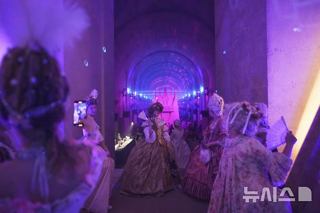 [베르사유=AP/뉴시스] 21일(현지 시간) 프랑스 파리 베르사유 궁전 오랑주리에서 열린 가면 무도회에 참가한 참가자들이 이동하고 있다. 2025.06.23.<font style="vertical-align: inherit;"><font style="vertical-align: inherit;"></font></font>