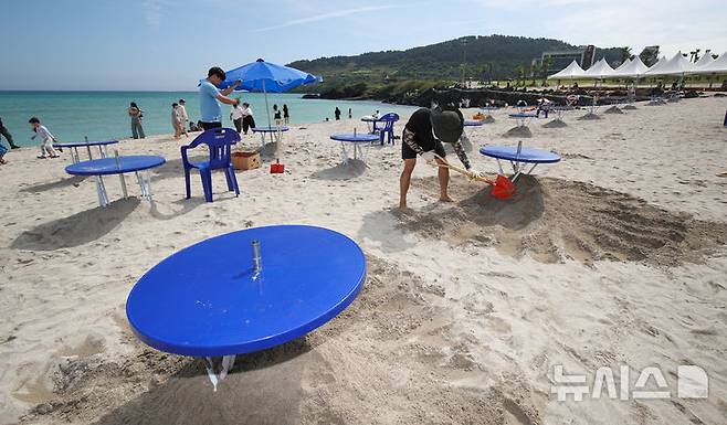 [제주=뉴시스] 우장호 기자 = 제주도 내 해수욕장 조기 개장을 하루 앞둔 23일 오전 제주시 조천읍 함덕해수욕장에서 피서객을 위한 파라솔 설치 작업이 한창이다. 2025.06.23. woo1223@newsis.com