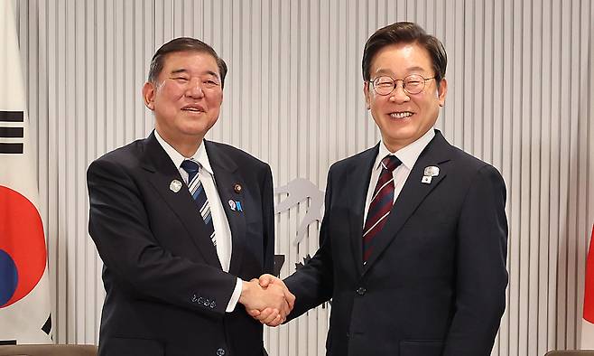 이재명 대통령이 지난 17일(현지시간) 캐나다 앨버타주 캐내내스키스 주요 7개국(G7) 정상회의장에서 열린 한일 정상회담에서 이시바 시게루 일본 총리와 악수하며 기념촬영을 하고 있다. 연합뉴스