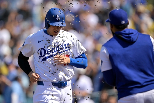 LA 다저스 오타니가 23일 워싱턴전 8회말 홈런을 치고 들어오자 동료가 해바라기씨를 뿌리며 축하하고 있다. AFP연합뉴스