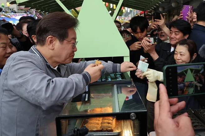 이재명 대통령이 대선후보 시절인 지난 5월 3일 강원도 태백의 산나물 축제장에서 붕어빵을 사며 지역화폐를 사용하고 있다. 연합뉴스