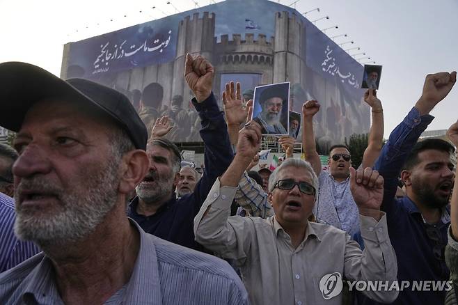 테헤란 반미 시위 (테헤란 AP=연합뉴스) 미국이 이란 핵시설을 공습한 다음날인 22일(현지시간) 테헤란 시내에서 열린 반미 집회에 참석한 이들이 하메네이 최고지도자의 사진을 들고 있다. 2025.06.23