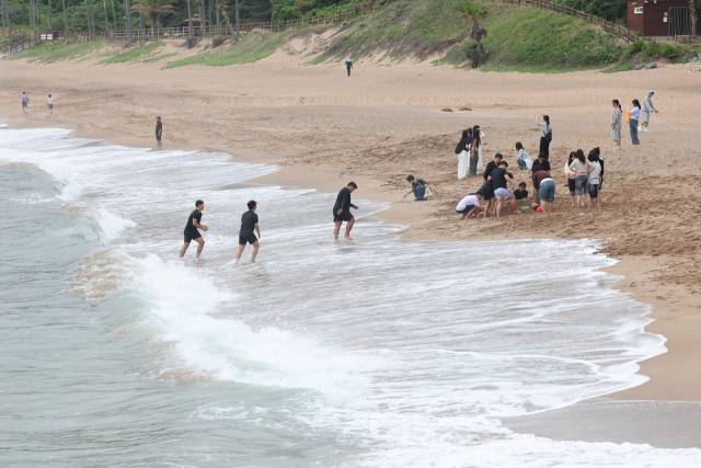 지난달 15일 오전 제주 서귀포시 중문해수욕장을 찾은 학생들이 해변가에서 현장체험학습을 하고 있다. 연합뉴스