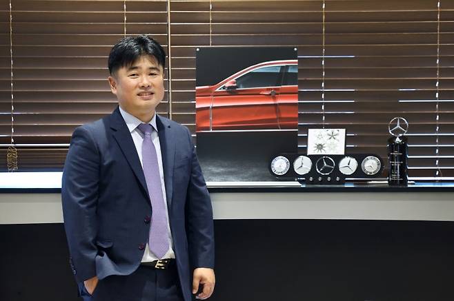 벤츠 한성 성수 서비스센터 정재윤 지점장이 올해의 테크니션 센터 트로피 앞에서 포즈를 취하고 있다. 사진=벤츠 공식딜러 한성자동차