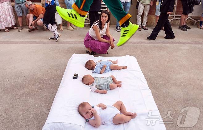 22일(현지시간) 스페인 부르고스 인근 카스트리요 드 무르시아 마을에서 열린 '엘 콜라초(El Colacho)'축제에서 악마를 상징하는 '콜라초'가 아기들을 뛰어넘고 있다.ⓒ AFP=뉴스1