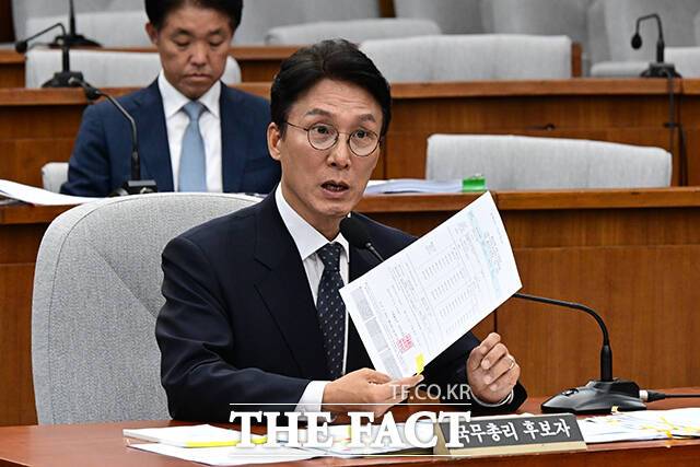 출입국 사실증명서를 들고 답변하는 김민석 후보자.