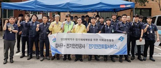 진교훈 강서구청장(맨 앞줄 노란색 민방위복 오른쪽)이 24일 한국전기안전공사 서울서부지사 직원들과 안전취약계층의 전기설비 안전점검에 앞서 기념촬영을 하고 있다. 강서구 제공.