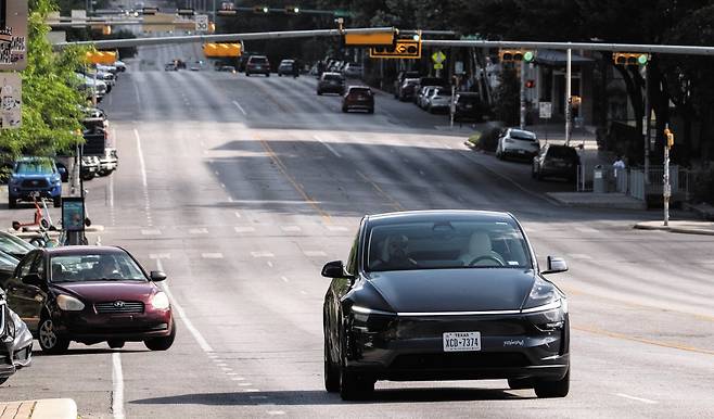 운전자 없이 안전거리 확보도 ‘척척’ 22일(현지 시각) 미 텍사스주 오스틴의 한 도로에서 테슬라의 로보(무인) 택시가 승객을 태우고 운행하고 있다. 이날 테슬라는 사전에 초청한 승객을 대상으로 오스틴의 일부 지역에서 로보 택시 서비스를 시작했다./로이터 연합뉴스