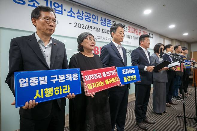 Participants hold signs calling for a freeze on the minimum wage during a press conference by South Korea’s small and medium-sized business community on the 2026 minimum wage, held at the Korea Federation of SMEs in Yeouido, Seoul, on June 23, 2025./Chang Lian-cherng