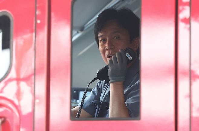 김영훈 고용노동부 장관 후보자가 23일 경북 김천역에서 ITX-마음 열차를 운행하기 위해 열차에 탑승해 배웅 나온 역무원에게 인사하고 있다. 김 후보자는 현직 한국철도공사(코레일) 기관사이며, 전 전국민주노동조합총연맹(민주노총) 위원장이다. 연합뉴스