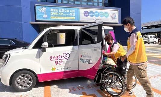 몸이 불편한 사람을 병원까지 데려다주는 부산시 동행매니저가 진료를 마친 휠체어 이용자를 차량에 태우고 있다. 부산시 제공