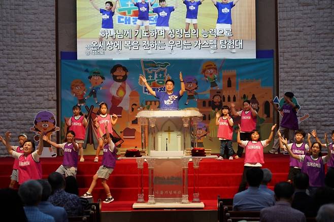 홍융희 부산 성민교회 목사가 지난 22일 교회에서 진행한 '어른성경학교' 때 설교에 앞서 교회학교 학생과 찬양하며 율동하고 있다. 성민교회 제공