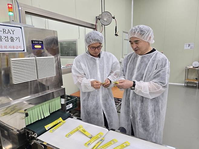 충남 서천군에 위치한 해담솔에서 민근식 해담솔 대표(오른쪽)와 곽태영 삼성전자 ESG&스마트공장지원센터 위원이 스틱형 김자반 제품을 살펴보고 있다. [서천 = 박승주 기자]