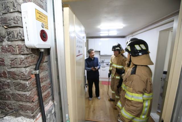 서울 종로구의 한 반지하주택에 설치된 ‘종로비상벨’ 시연 과정에서 침수 신고를 받은 소방관이 현장에 출동해 있다. 종로구청 제공