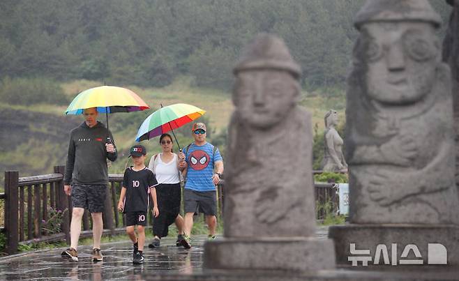 [서귀포=뉴시스] 우장호 기자 = 올해 첫 장맛비가 내리는 12일 오전 제주 서귀포시 대정읍 송악산 둘레길에서 우산을 쓴 관광객들이 걸어가고 있다. 2025.06.12. woo1223@newsis.com