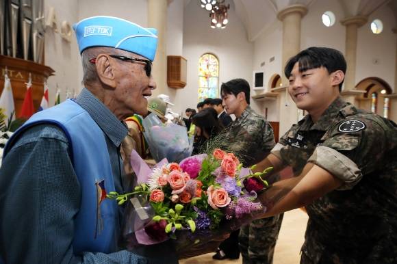 24일 대구 달서구 계명대 성서 캠퍼스에서 총학생회 주관으로 열린 6·25전쟁 제75주년 추념식에 참석한 예비역 재학생들이 참전용사들에게 꽃다발을 전달하고 있다. 계명대 제공