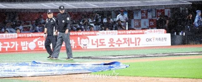 24일 수원KT위즈파크에서 열린 2025KBO리그 LG트윈스와 KT위즈의 경기에서 폭우가 쏟아져 6회초 수비를 마치고 경기가 중단된 가운데 그라운드 사정을 살피는 심판과 그라운드 관리소장.  /사진=강영조 선임기자