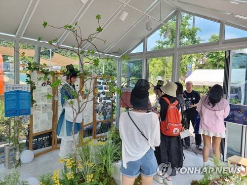 정원에 기억을 내려놓다 (서울=연합뉴스) 서윤호 인턴기자 = 지난 19일 오후 서울 동작구 보라매공원에서 열린 서울국제정원박람회에서 '정원을 여행하는 돌' 프로그램 참가자들이 프로그램 종료 전 부스를 관람하고 있다. 2025.6.24