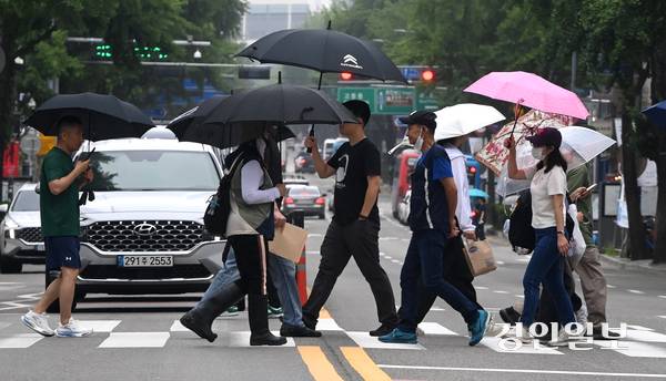 비가 내린 25일 오후 수원역 인근 횡단보도에서 우산을 쓴 시민들이 발걸음을 재촉하고 있다. 2025.6.25 /최은성기자 ces7198@kyeongin.com