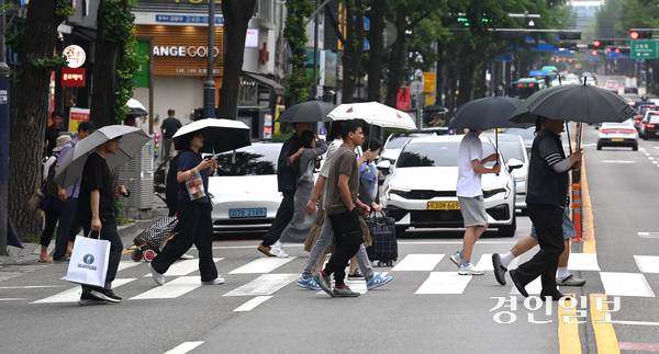비가 내린 25일 오후 수원역 인근 횡단보도에서 우산을 쓴 시민들이 발걸음을 재촉하고 있다. 2025.6.25 /최은성기자 ces7198@kyeongin.com