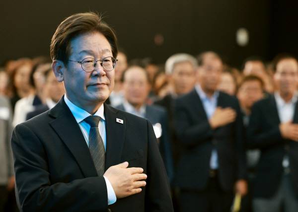 이재명 대통령이 25일 광주광역시 국립아시아문화전당에서 열린 '광주시민·전남도민 타운홀미팅'에 참석해 국기에 경례하고 있다.연합