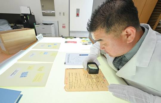 육군은 6.25전쟁 75주년을 맞아, 23일 충남 계룡대 육군기록정보관리단에서 '중요 역사기록물 복원사업' 현장을 공개했다. 사진은 복원 관계관이 확대경을 이용하여 보존 기록물의 손상도를 확인하고 있는 모습. 사진출처: 육군