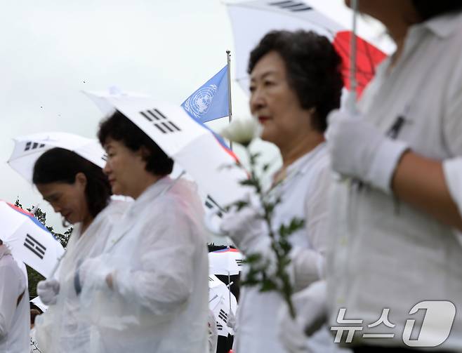 25일 오전 부산 남구 유엔기념공원에서 열린 제75주년 6·25전쟁 참전 유엔전몰용사 추모제에서 태극기 우산을 쓴 참석자들이 유엔군 전몰장병 묘역을 참배하고 있다. 2025.6.25/뉴스1 ⓒ News1 윤일지 기자