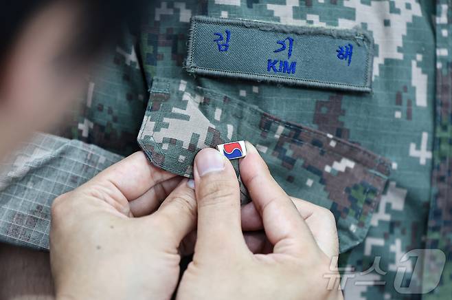 25일 서울 중구 서울역 대합실에 마련된 '태극기 부스'에서 군인들이 태극기 배지를 패용하고 있다. 2025.6.25/뉴스1 ⓒ News1 김도우 기자