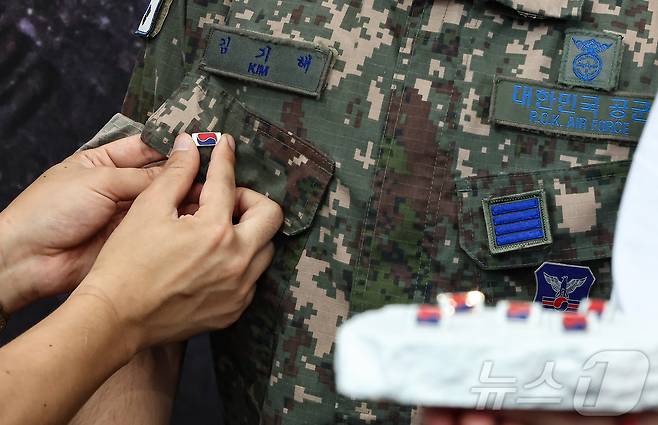 25일 서울 중구 서울역 대합실에 마련된 '태극기 부스'에서 군인들이 태극기 배지를 패용하고 있다. 2025.6.25/뉴스1 ⓒ News1 김도우 기자
