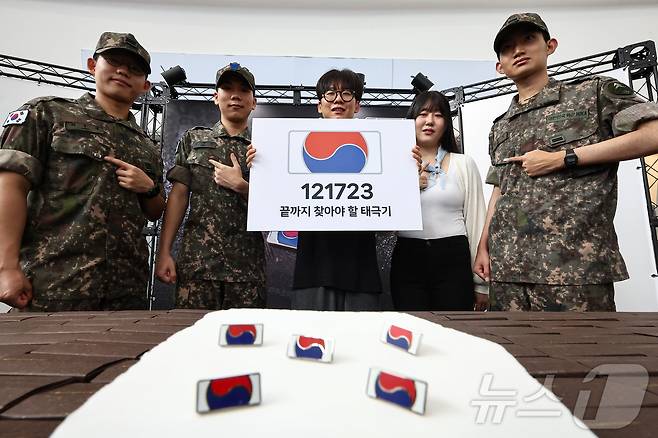 25일 서울 중구 서울역 대합실에 마련된 '태극기 부스'에서 군인들과 시민들이 태극기 배지를 패용 후 기념촬영 하고 있다. 2025.6.25/뉴스1 ⓒ News1 김도우 기자