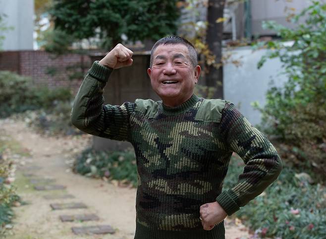 서울 서초구 자택에서 만난 방송인 이상용이 초록색 군복 스웨터를 입고 뽀빠이처럼 주먹을 들어 보였다. ‘우정의 무대’는 1997년 종영했지만 중고 시장에서 구한 이 스웨터는 30년 넘게 아끼며 입고 있다고 했다. /박상훈 기자