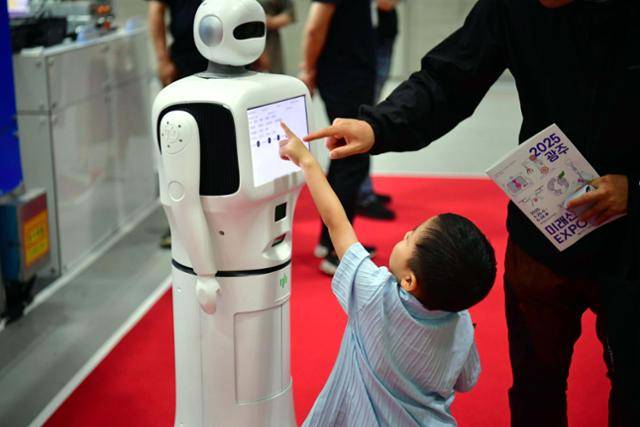 25일 오후 광주 서구 김대중컨벤션센터에서 열린 2025 광주미래산업엑스포에서 한 어린이가 AI로봇을 가르키고 있다. 뉴시스