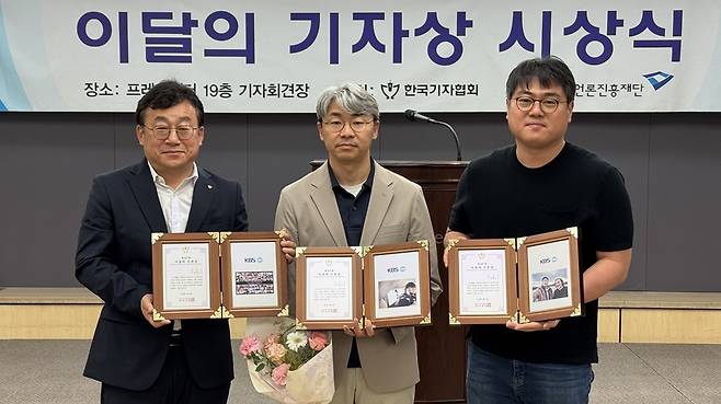 우한울 기자(가운데)가 우크라이나 현지 취재로 시상식에 참석하지 못한 동료들의 상패를 들고 기념 사진을 찍고 있다. /한국기자협회