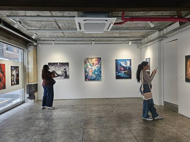 BTS fans view works in the “Presence in Absence” exhibition in Seoul. (Park Yuna/The Korea Herald)