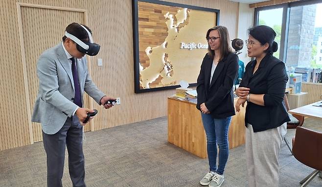 제주해녀문화를 주제로 가상현실 게임을 개발하고 있는 미국 올드 하라 스튜디오의 카렌 스트리징거 대표(사진 가운데)가 최근 제주도청에서 오영훈 제주지사를 만나 게임 개발 과정 등을 논의했다. 사진은 오영훈 지사가 직접 헤드셋을 착용해 해당 게임을 체험하고 있는 모습.[제주도 제공]