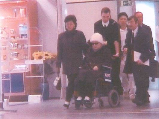 암치료를 위해 프랑스 파리에 입국하는 모습의 고영희. 흰모자를 쓰고 휠체어에 앉아 거동이 불편한 모습을 보여주고 있다. [문예춘추]