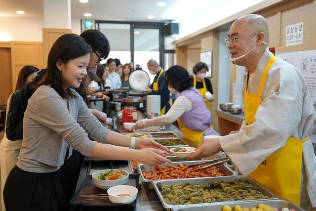 ‘청년밥심’에서 묘장 스님(오른쪽)이 식사를 배식하는 모습.  연화사 제공
