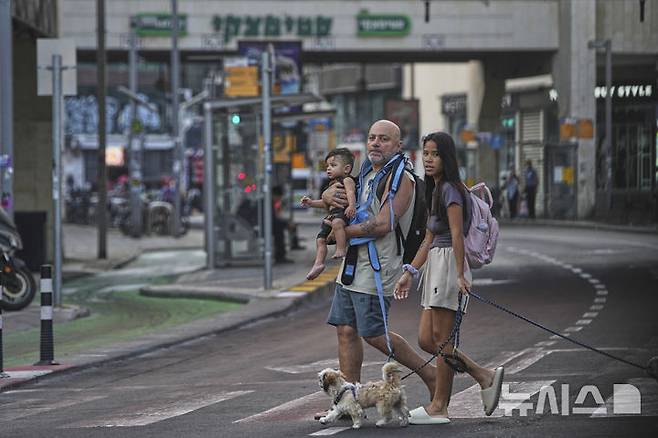 [텔아비브=AP/뉴시스] 24일(현지 시간) 이스라엘 텔아비브에서 이란의 미사일 공습경보에 지하 주차장으로 대피했던 주민들이 경보가 해제되자 밖으로 나오고 있다. 2025.06.24.