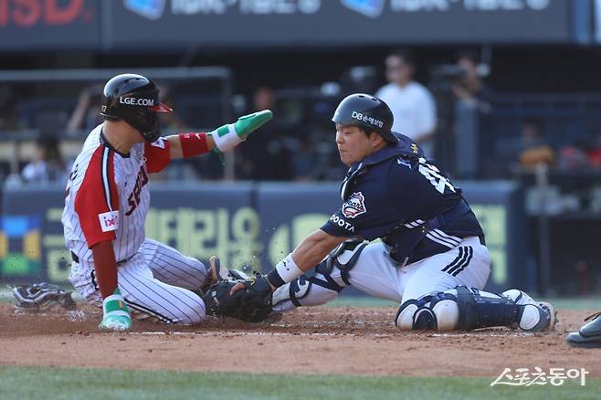 두산 김기연(오른쪽)이 22일 잠실구장에서 열린 LG와 원정경기 도중 홈으로 쇄도한 주자를 아웃시키려고 태그를 시도하고 있다. 사진제공|두산 베어스