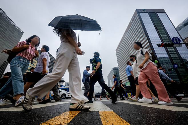 부슬비가 내리는 오전 서울 종로구 광화문 네거리에서 시민들이 출근길을 서두르고 있다. /뉴스1
