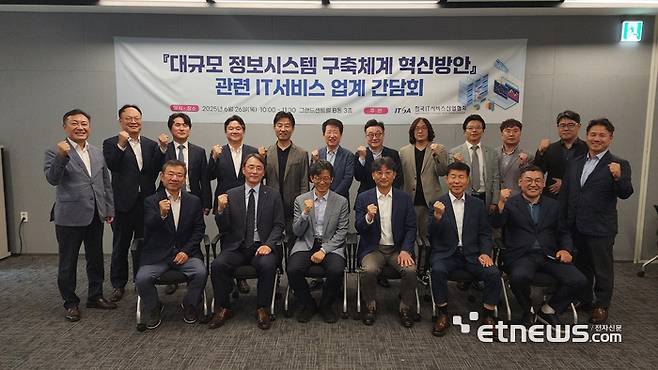 한국IT서비스산업협회가 26일 서울 그랜드센트럴에서 '대규모 정보시스템 구축체계 혁신방안 관련 IT서비스 업계 간담회'를 개최한 가운데 김회수 행안부 디지털정부국장(앞줄 왼쪽에서 세 번째)을 비롯해 주요 참석자들이 파이팅을 외치며 기념촬영했다. 한국IT서비스협회 제공