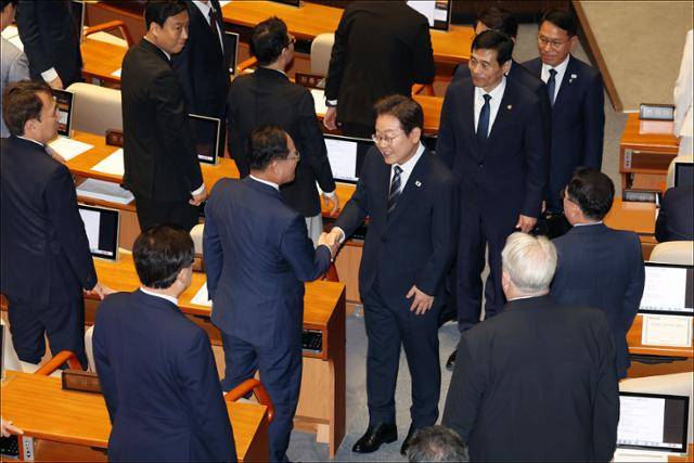 이재명 대통령이 26일 서울 여의도 국회 본회의장에서 추가경정예산안(추경안) 시정연설을 마친 뒤 야당인 국민의힘 의원들과 인사하고 있다. 고영권 기자