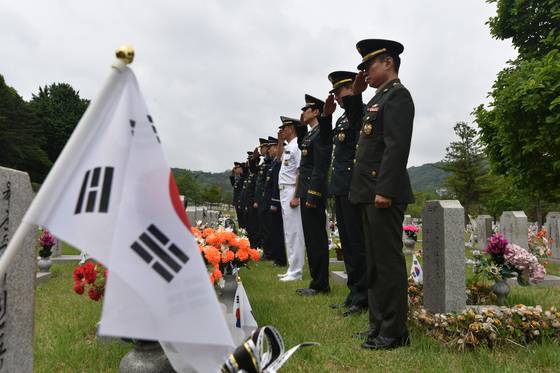 국방부 전사망민원조사단(민조단) 부대원들이 국립현충원에서 순직자의 묘소에 예우를 표하고 있다. 사진 국방부