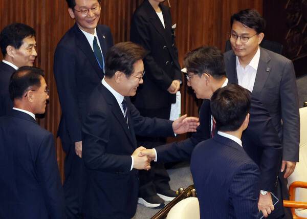 이재명 대통령이 26일 추가경정예산 시정연설을 마친 뒤 국회 본회의장에서 국민의힘 권성동 의원과 인사하고 있다. 연합뉴스
