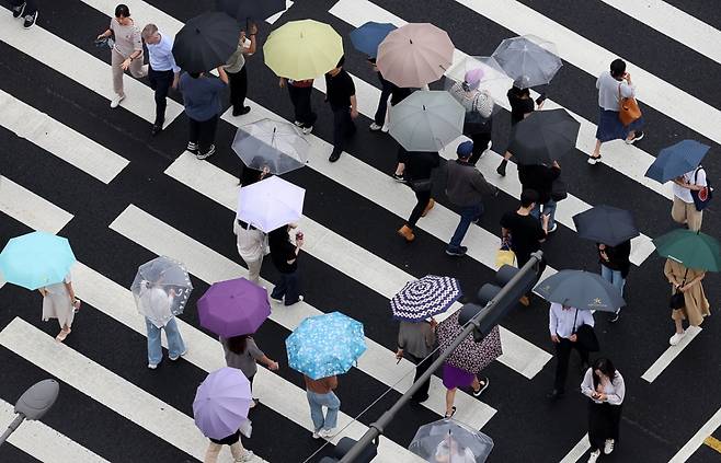 장마전선 영향으로 비가 내린 25일 오후 서울 중구 서울시청 인근에서 시민들이 우산을 쓰고 이동하고 있다. /사진=뉴시스.